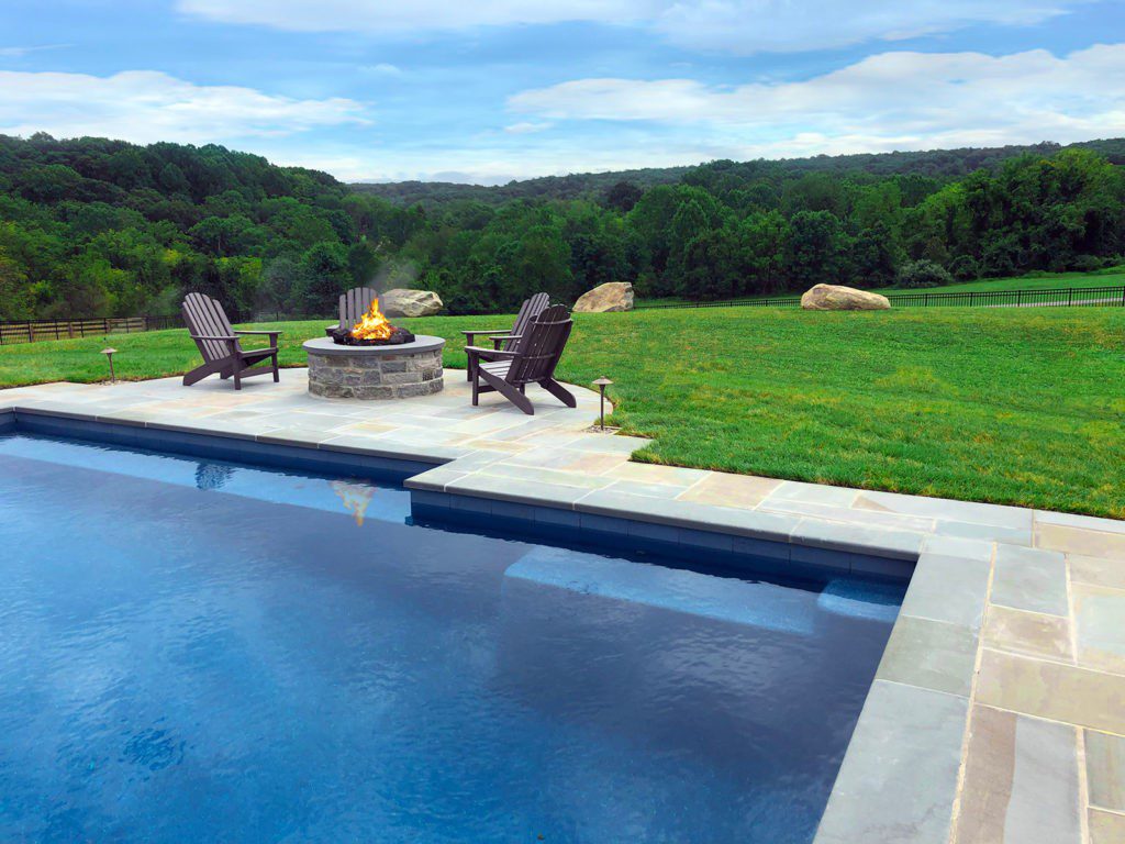 Outdoor fire pit in large backyard by pool