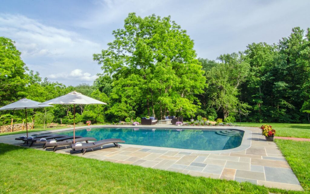 A flagstone pool deck surrounding an in-ground pool.