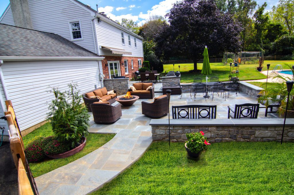 A beautiful stone walkway leads to a stone patio designed by Dutchies Stoneworks.