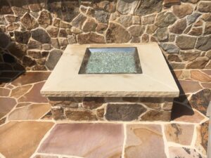 A fire table on irregular Tennessee stone provides a place for food and drinks.