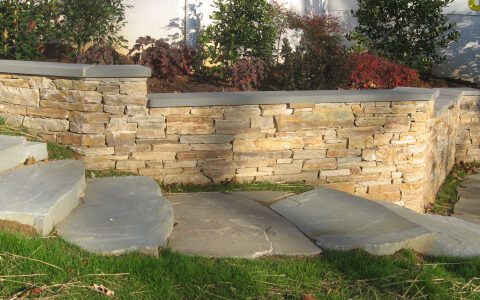 A flat-stacked stone retaining wall.