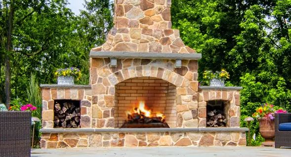 An outdoor stone fireplace with round stone.